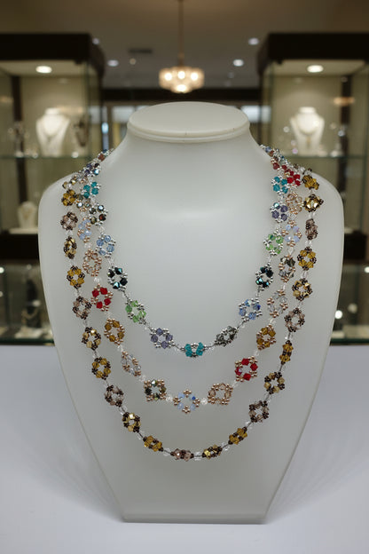 Three colorful beaded necklaces on a white bust.
