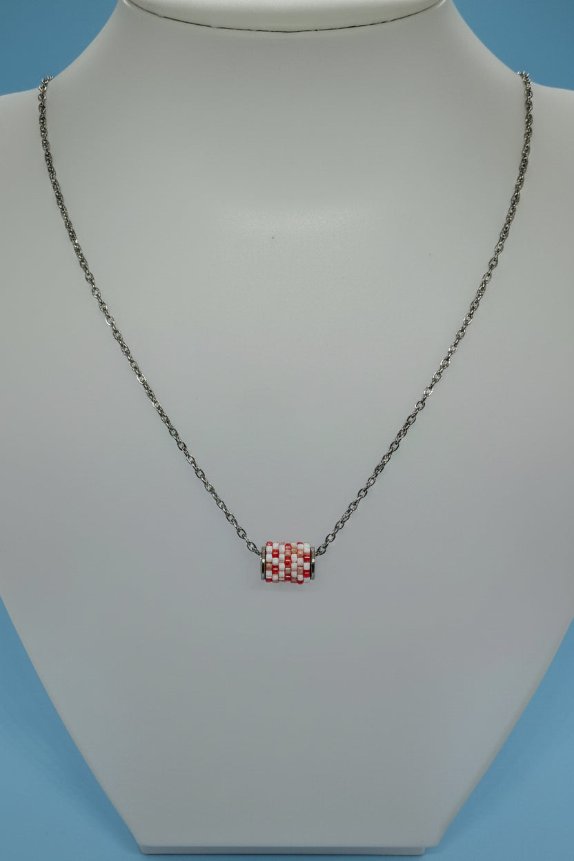 Silver necklace with a beaded woven pendant on a white bust with a blue background