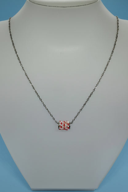 Silver necklace with a beaded woven pendant on a white bust with a blue background