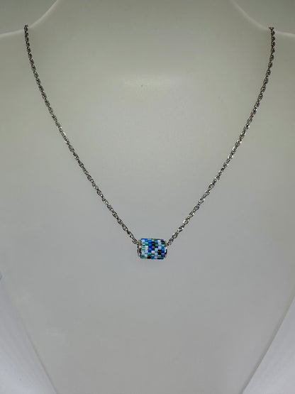 Silver necklace with a beaded woven pendant on a white background